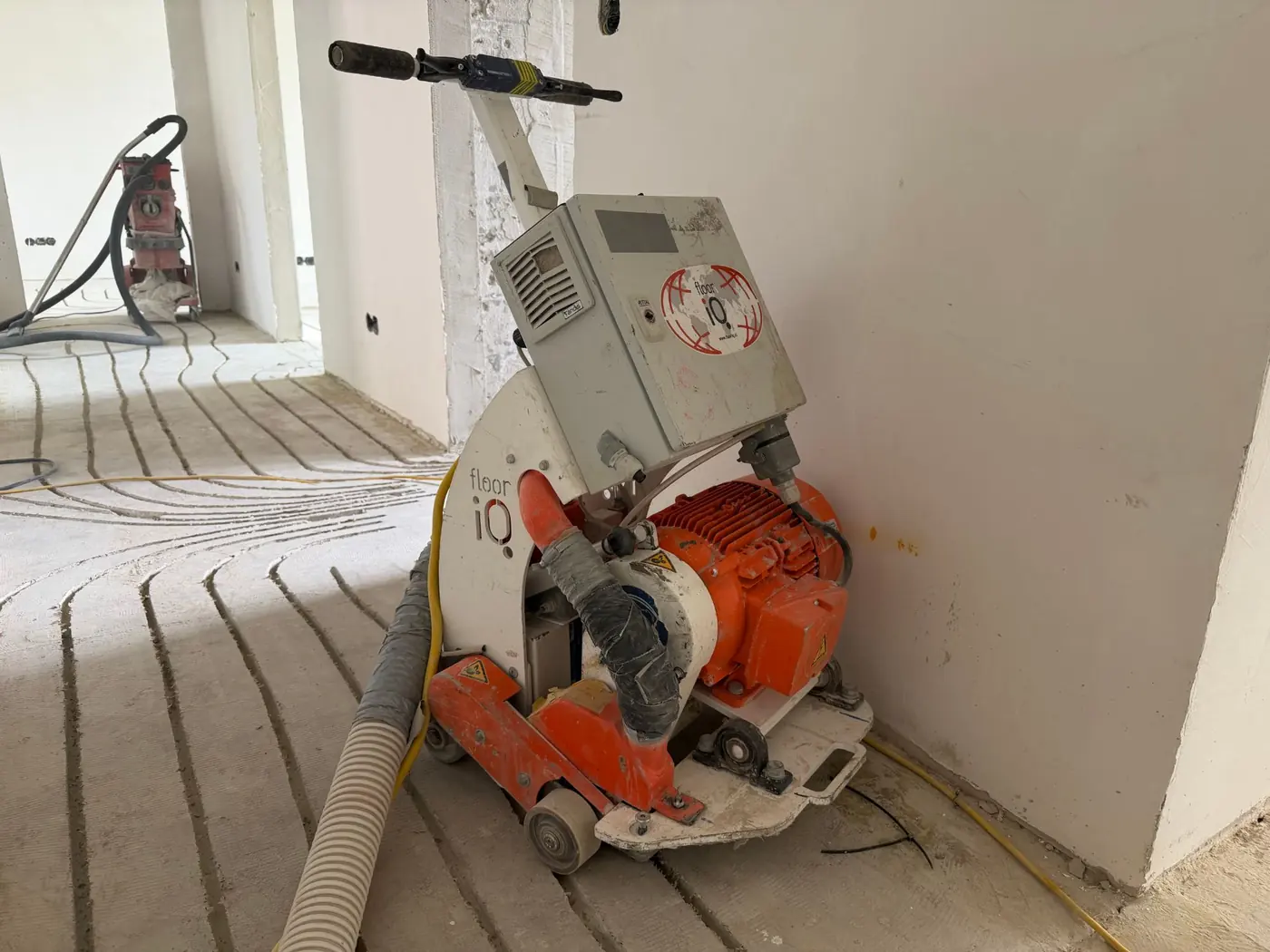 Fräsmaschine mit Absaugschlauch im Rohbau-Raum